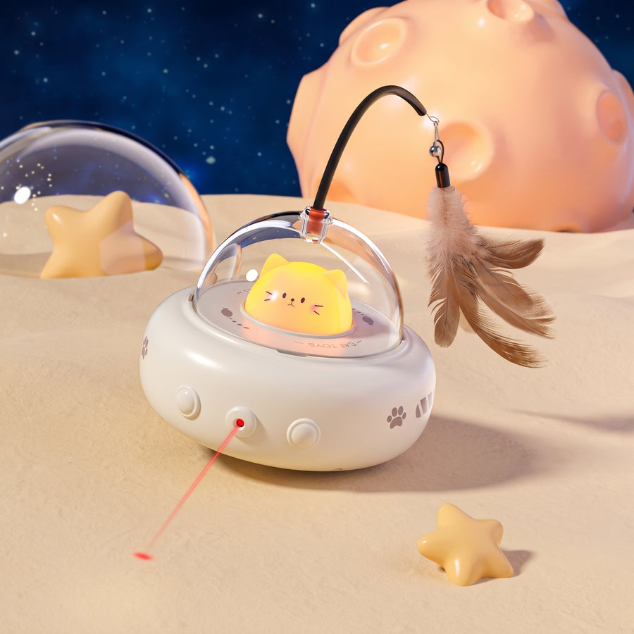 UfoKitty electric cat toy with laser and feather wand on a sandy dune with moon backdrop