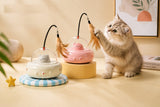 Two cats playing with the pink and white UfoKitty toys on a table